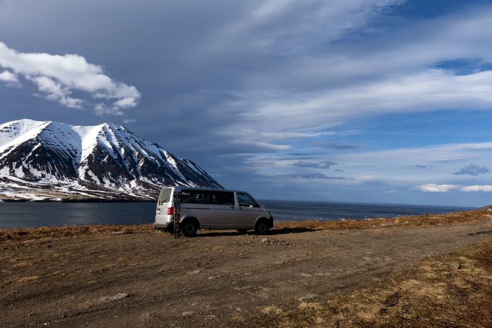 A van parked by the sea.