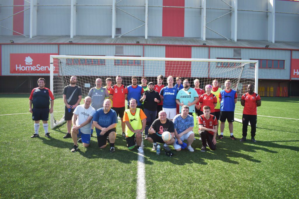 Members of Walsall's 'Beat the Block' sessions stand in front of the goal.