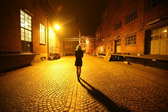 A woman walking alone at night.