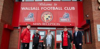 Members of the Walsall Community Programme stand outside the entrance.