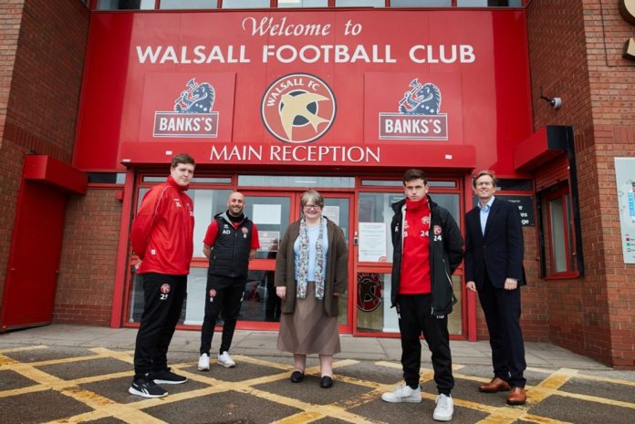 Members of the Walsall Community Programme stand outside the entrance.