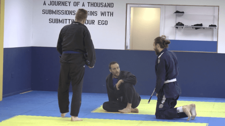 Three people practicing jiu-jitsu