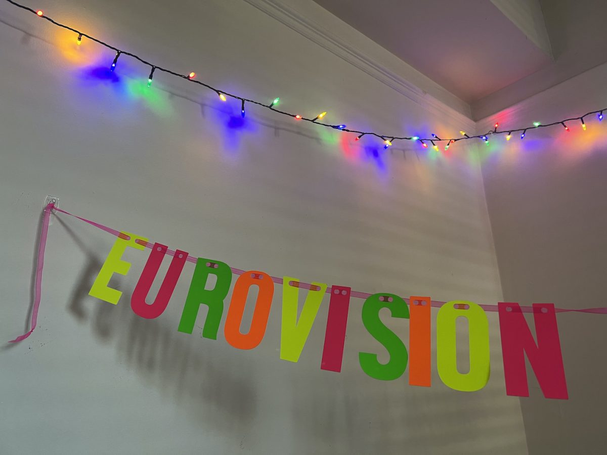 A neon Eurovision banner surrounded by fairy lights.
