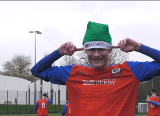This image shows Derby Men's 3rds player Lewis Smith celebrating the opening goal with a Popworld themed hat
