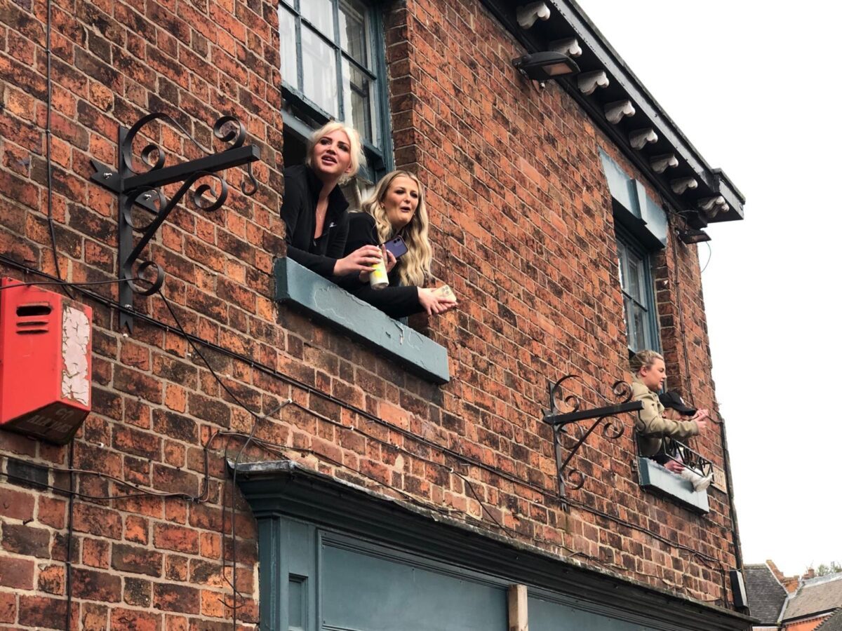 This is an image of two people watching Shrovetide from a pub window