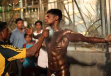 A body builder gets sprayed with tan paint before taking the stage during the Mumbai Bodybuilding competition