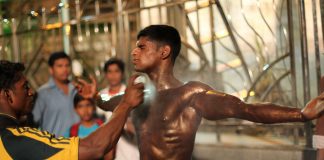 A body builder gets sprayed with tan paint before taking the stage during the Mumbai Bodybuilding competition