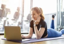 Woman enjoying a break from working out to use laptop | Credit: Quality Stock / Alamy Stock Photo.