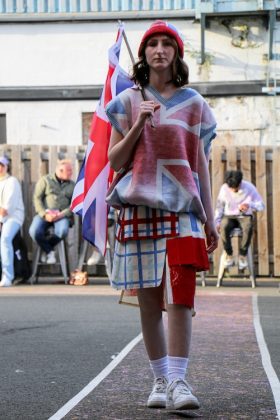 A model walking down the runway wearing an outfit from a first-year student inspired by the Great Britain.