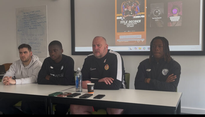 Four men sat at a table, facing a crowd ahead of the title decider