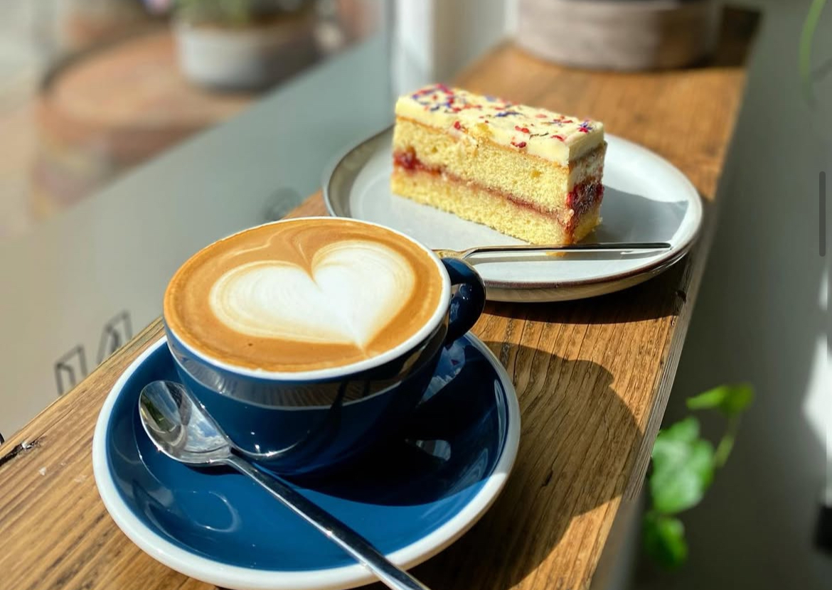 An image showing an Oat Milk Latte and Bakewell Bite at Sanchini's Coffee Bar.