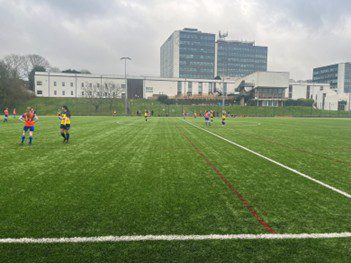 Derby women's seconds (orange shirt, blue shorts) in action against University of East Anglia women's seconds (yellow shirt, blue shorts).
