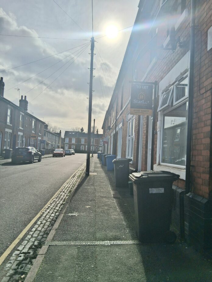 An image of a street with houses for sale