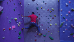 Raj climbing a bouldering wall at alter rock.