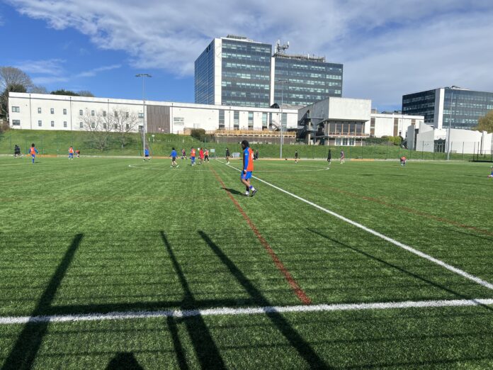 Derby university trial match, with an orange team player closest to the sideline.
