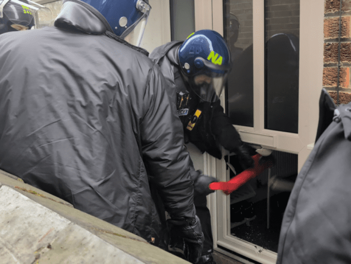 Image of police raiding a property.