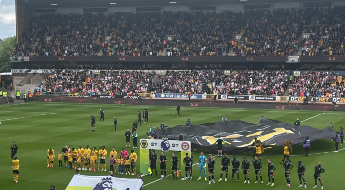 This image shows Wolves and Brentford players lining up prior to kick-off in their game in the 24/25 Premier League season at Molineux.