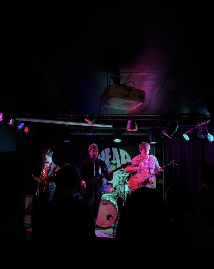This image shows Headwired playing their headline gig at Katie Fitzgerald's music venue in Stourbridge. The four band members are playing their hit single Carousel.